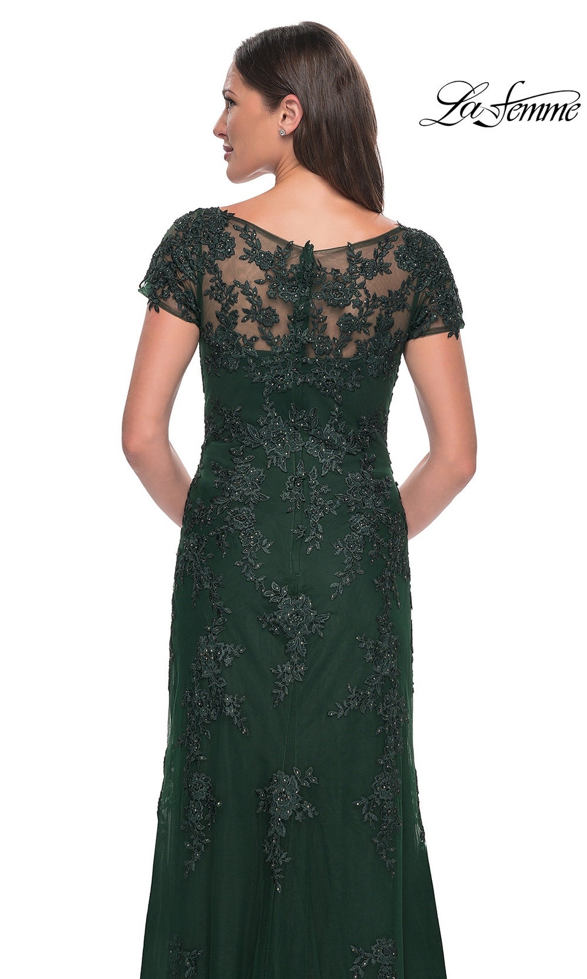 A woman seen from behind wearing the floor-length, dark green lace La Femme 29792 formal dress with short sleeves and an embroidered bodice.